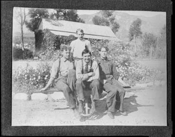 Four men of the operating crew sitting outside a company facility at Mill Creek #1 Hydro Plant.  The men are E.P. Chase
