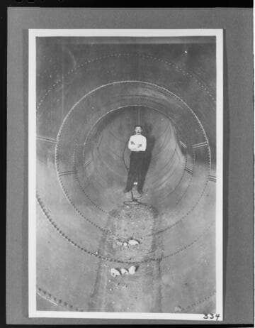 A man standing inside the completed section of penstock at the Kern River #1 Hydro Plant