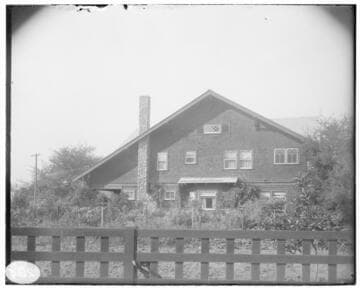 Side view of a two story Arts & Crafts home with open gables and wide overhanging eves