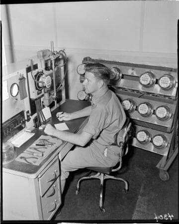 Young man at desk testing electric meters