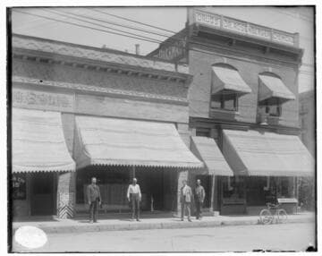 Four people standing in front of the Edison Electric Company's Pasadena Local Office
