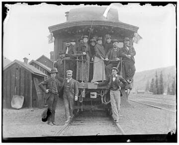 Group on caboose and railroad tracks