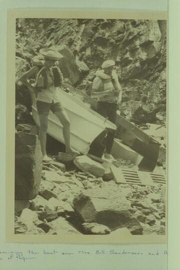The wreck of the Harris-Brennan outboard below Hance Rapid.  Examining the boat are Mrs. Bill Sanderson and Al Roueche, both of Page