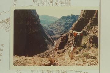 Cairn to the west and about 100' up from the bottom of the canyon at the head of the big drop in Trail Canyon.  It is 1/2" south of 35 degrees 52' 30" on Diamond Peak Quad