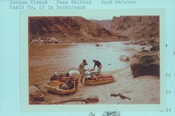 Loading Yaks at camp at Mile 202.25, right bank.  Jorgen Visbak; Buzz Belknap; Dock Marston.  Rapid No. 23 in background