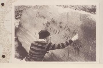 Dock Marston points up the Best Expedition inscription at Rapid 16 in Cataract CAnyon.  "Camp NO 7 Hell To Pay No 1 Is Sunk & Down."  Inscription was cut by Chief Boatman Harry McDonald after party had foundered boat No. 1 on July 21, 1891