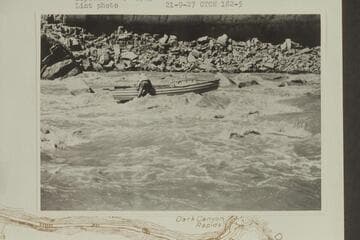 USGS boat on rocks in Dark CAnyon Rapid