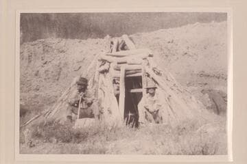 Abandoned hogan on the San Juan at mouth of canyon that is 10 miles by stream above the Colorado.  Looking west.  Bert Loper to right.  Heber Christensen to left