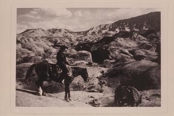 Dan Lehi rides down the slick rock from the rim of the mesa west of Nasja Creek.  Cha Butte is upper left.  Navajo Mountain is upper right.  The sloping mesa at upper right is 4903.  Nasja Creek is center