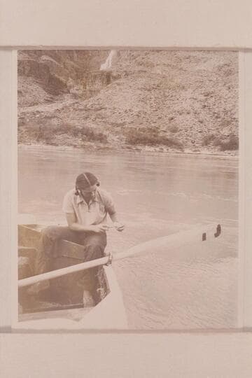 Anne Desloge cleaning fish.  The boat is moored at the beach below Tapeats Creek