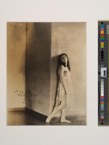 [Terese Van Grove, standing against a Wall]