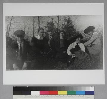 Edwin Hubble seated outside with two unidentified teenage boys and three young women, seated on rocks, outdoors