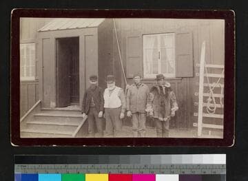 Three Caucasian men and one Alaska native outside house