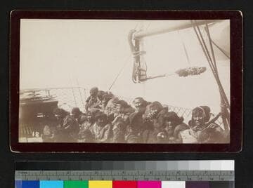 Group of Alaska natives sitting on unidentified boat deck