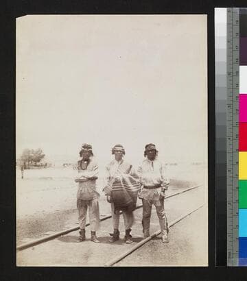 Three Southwest Indian men standing on railroad tracks