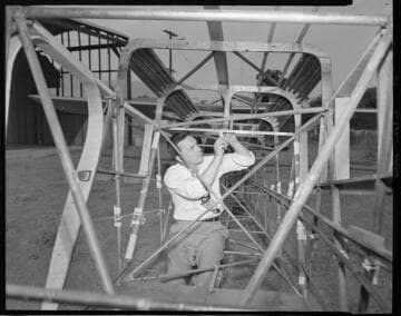 Man working on airplane frame with 2 variants of man with single engine airplane