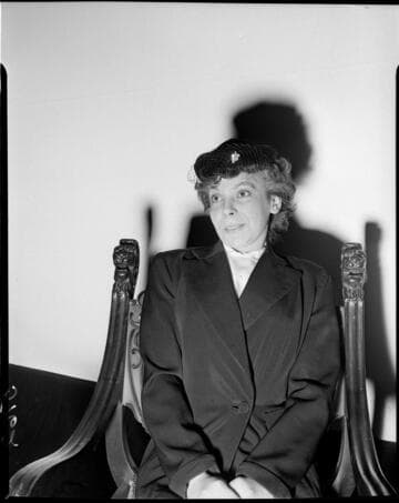 Lady seated in chair against white backdrop
