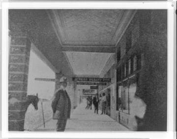 Covered boardwalk with store fronts, hitching post