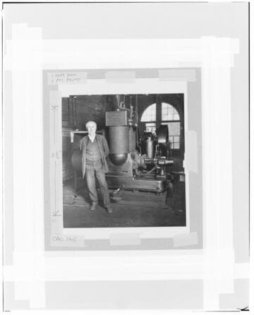 Thomas Edison standing beside a bi-polar generator of his design, about 1885