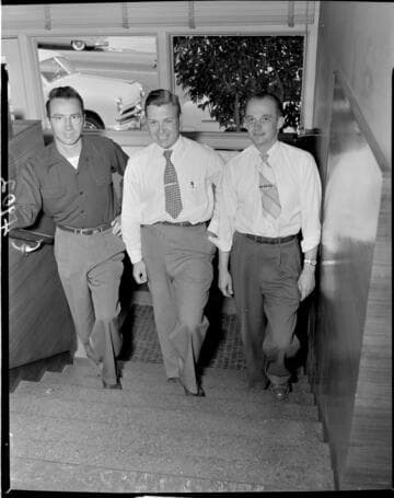 Three men walking up steps