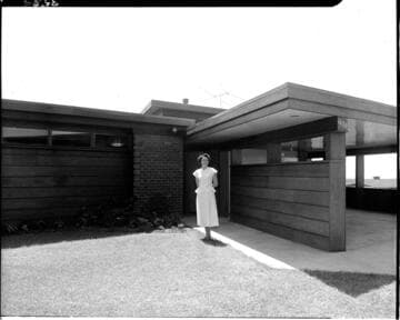 Lady standing in front of house