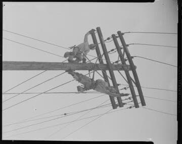 Linemen mounting overhead crossarm