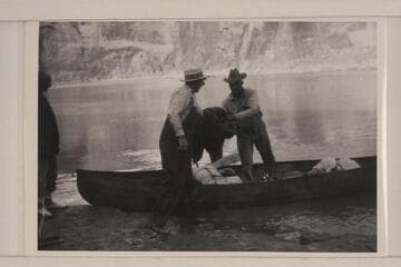Loading one of Dave Rust's folding canvas boats; Glen Canyon.  Bert Loper is at left
